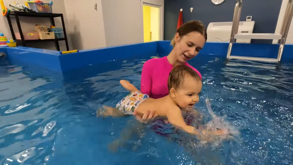 Certified swim instructor teaching water safety to a baby in a pool